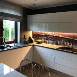 Nowoczesna kuchnia z białymi szafkami, czarnym blatem i fototapetą z nocnym widokiem na miasto podświetloną od dołu. Widoczny zlew, płyta indukcyjna i metalowe krzesła.