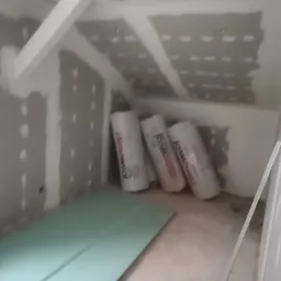 Poddasze w trakcie ocieplania i montażu płyt karton gips: widoczne płyty G-K, wełna mineralna Climowool i częściowo zagruntowane ściany