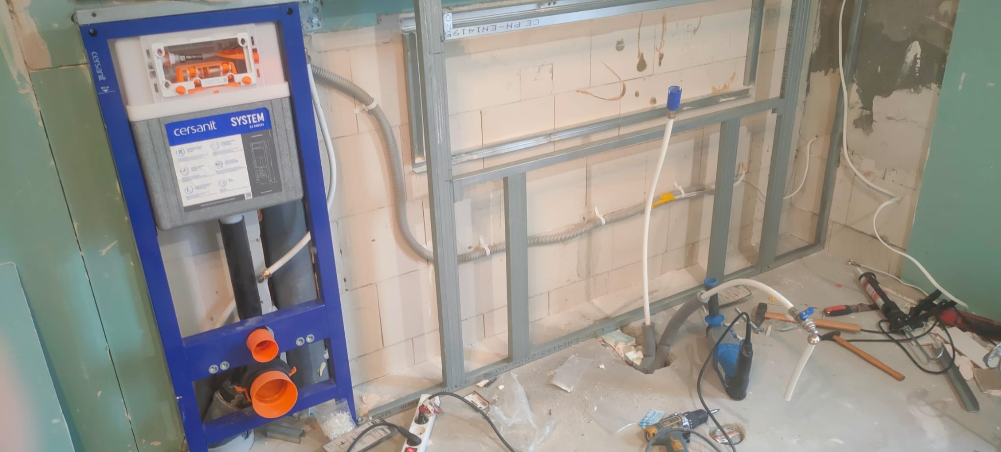 Stelaż podtynkowy Cersanit zamontowany w łazience w trakcie remontu, widoczne przewody i konstrukcja metalowa pod zabudowę