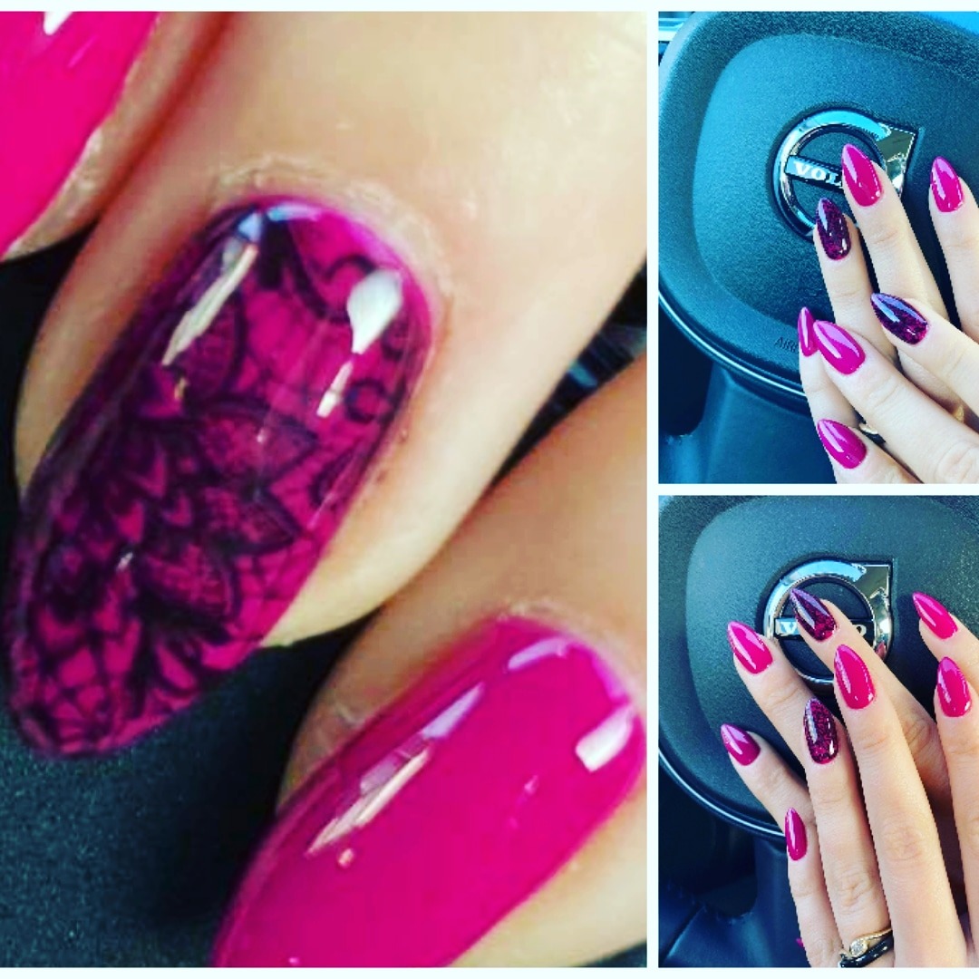 Zbliżenie na dłoń z manicure hybrydowym: jeden paznokieć z czarnym, koronkowym wzorem na różowym tle, pozostałe w intensywnym, jednolitym różu, oraz dłonie na kierownicy samochodu marki Volvo...