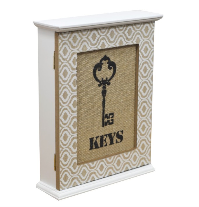 Biała szafka na klucze z dekoracyjnym wzorem i grafiką klucza na płótnie.
