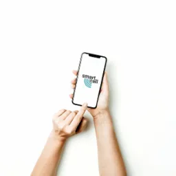 Dłonie trzymające smartfon z aplikacją 'smart Call' na białym tle, palec wskazujący na ekran.