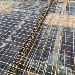 Zbrojenie stropu żelbetowego z widocznymi prętami i siatką zbrojeniową, przygotowane do zalania betonem.