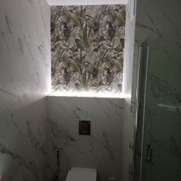 ELITE DE LUXE - Nowoczesna łazienka z marmurowymi płytkami, toaleta podwieszana z chromowanym przyciskiem, tropikalna tapeta podświetlona ledami i kabina prysznicowa.