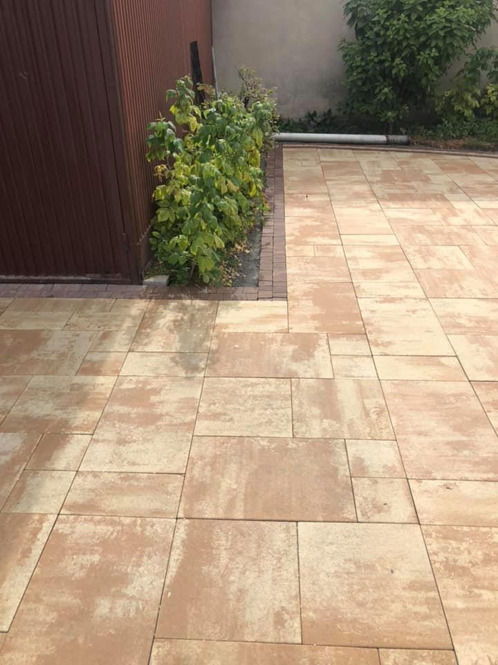 Ułożona kostka brukowa w Sosnowcu, z widocznymi różnicami w odcieniach poszczególnych elementów i obrzeżem z ciemniejszej kostki.