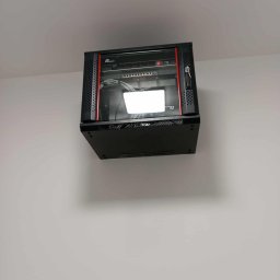 Woj-Bol Technology Wojciech Ból - Czarna szafa rack z czerwonymi akcentami, zamontowana na białej ścianie. Widoczne kable i urządzenia wewnątrz. Kąt ujęcia od dołu.