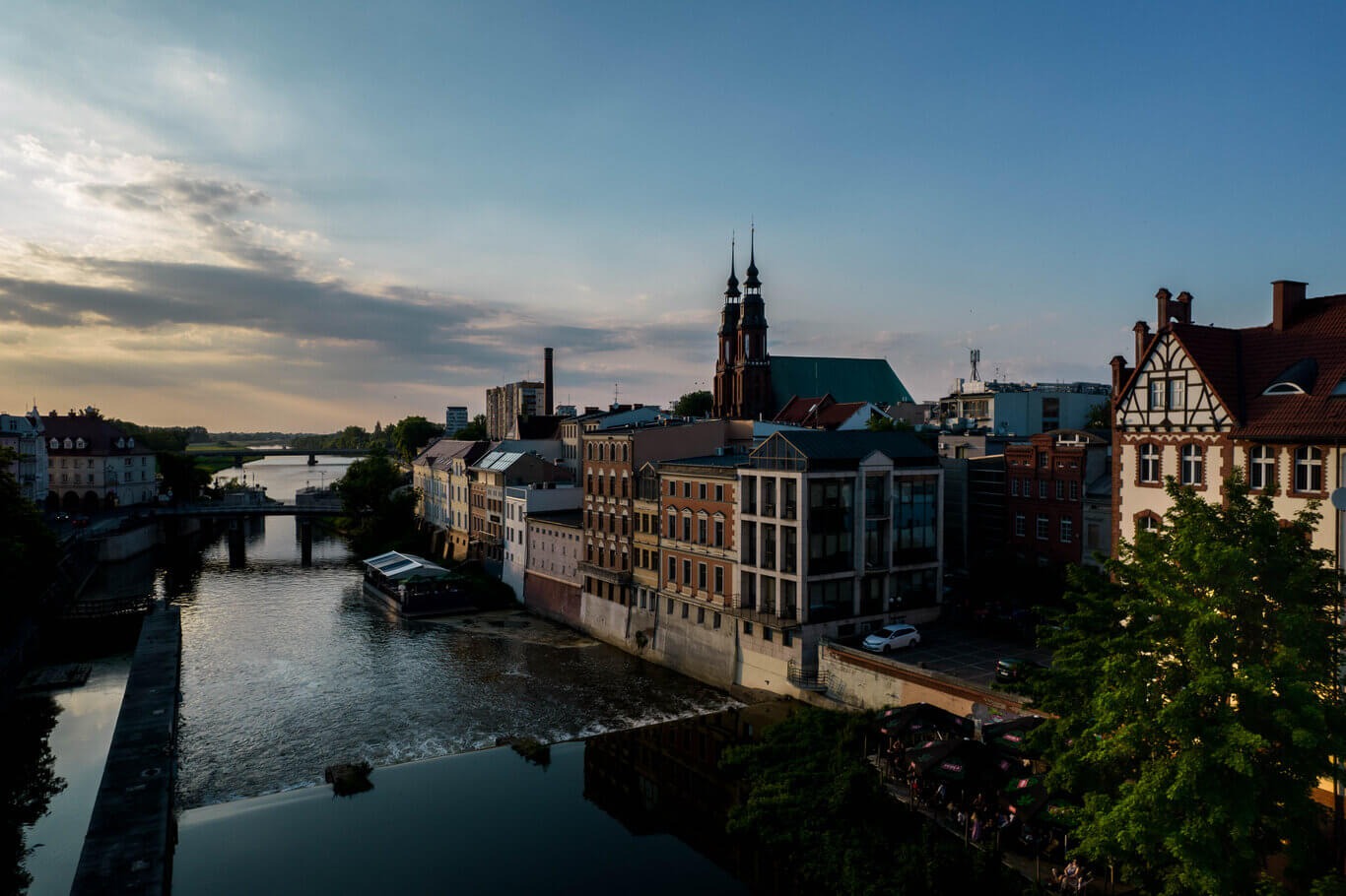 Panorama Opola nad Odrą o zmierzchu, z widoczną katedrą i zabytkową architekturą.