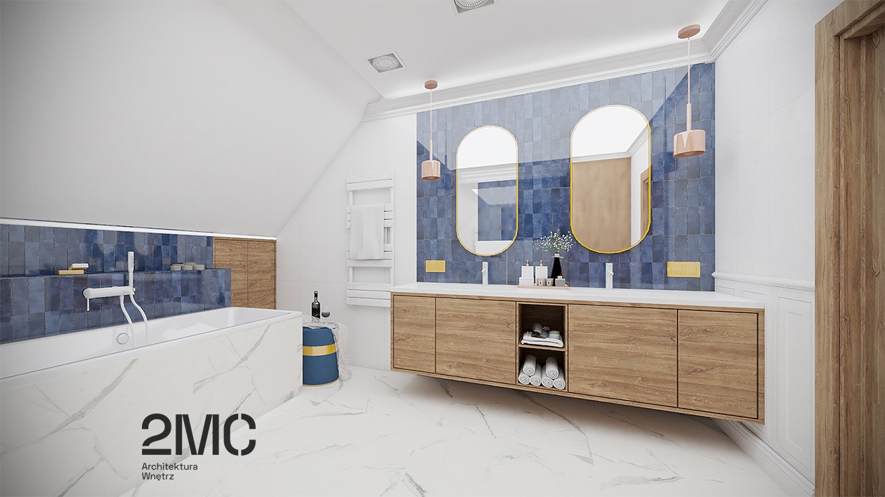 Jasna łazienka na poddaszu z marmurową podłogą, niebieską mozaiką na ścianach, drewnianą szafką pod umywalką, owalnymi lustrami w złotej ramie i wiszącymi lampami w kolorze pudrowego różu.