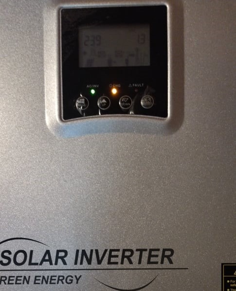 Szary inwerter solarny z wyświetlaczem pokazującym napięcie 239V i prąd 13A, z diodami sygnalizującymi stan pracy: zielona AC/INV, pomarańczowa CHG i niedziałająca FAULT.