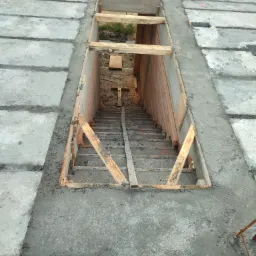 Wykop pod schody w surowym betonowym stropie, drewniane szalunki i zbrojenia widoczne.
