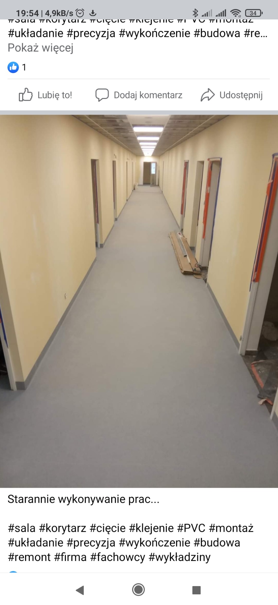 Długi korytarz w budynku biurowym po remoncie, z szarą podłogą z wykładziny PVC, świeżo pomalowanymi ścianami na kolor jasnożółty i przygotowanymi otworami drzwiowymi z widocznymi zabezpieczeniami.