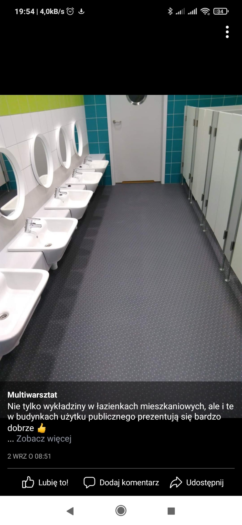 Publiczna toaleta w Gdyni po remoncie, z rzędem białych umywalek z okrągłymi lustrami i kabinami WC po prawej stronie, wykończona turkusowymi płytkami i szarą podłogą w kropki.