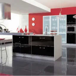 Nowoczesna kuchnia z czarnymi, lakierowanymi frontami szafek, szarym blatem, czerwonymi akcentami oraz dwoma wiszącymi lampami z przezroczystymi kloszami.