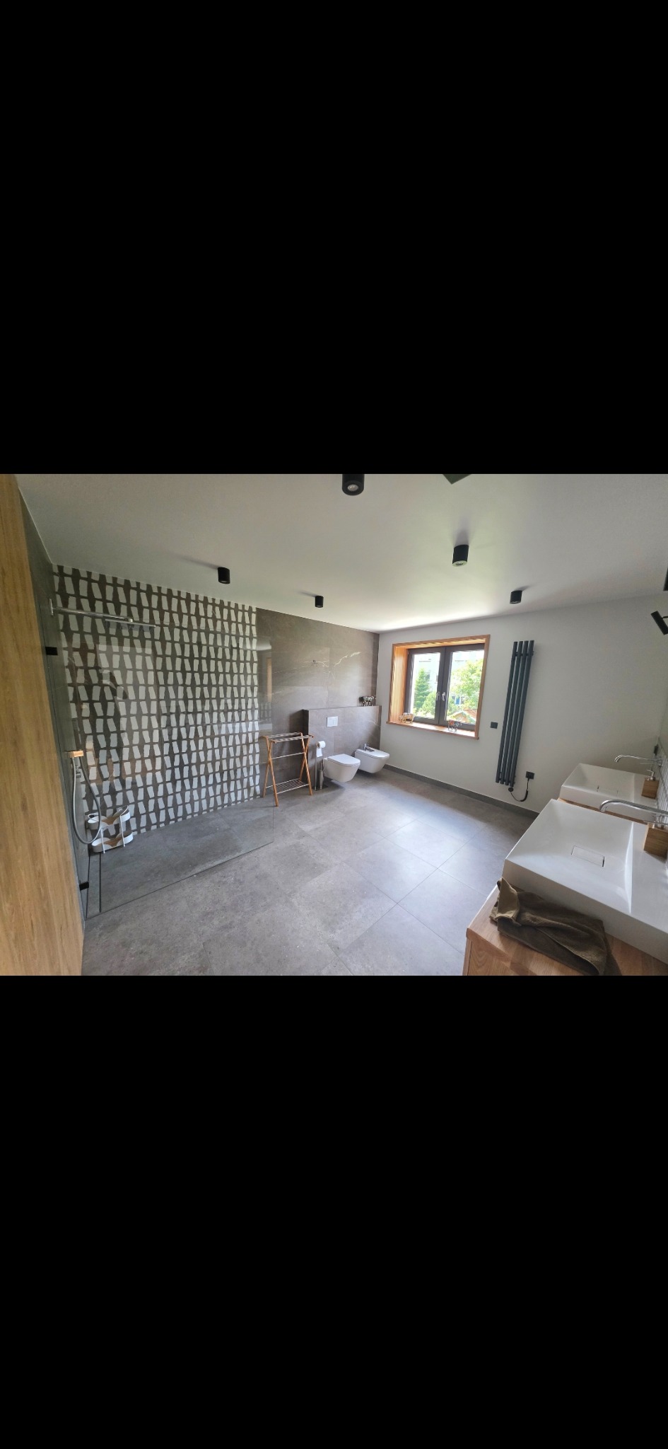 Nowoczesna łazienka z kabiną walk-in i podwójną umywalką w Jaworzynie Śląskiej. Szara kolorystyka, minimalistyczny design, okno z widokiem na zieleń.