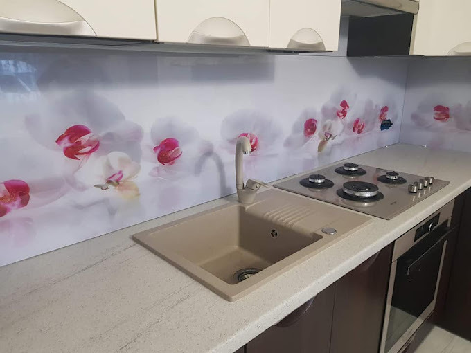 Szklany panel kuchenny z motywem orchidei, zamontowany nad blatem i zlewem. Realizacja w Radomiu. Dekoracyjny element wystroju kuchni, odbijający światło.