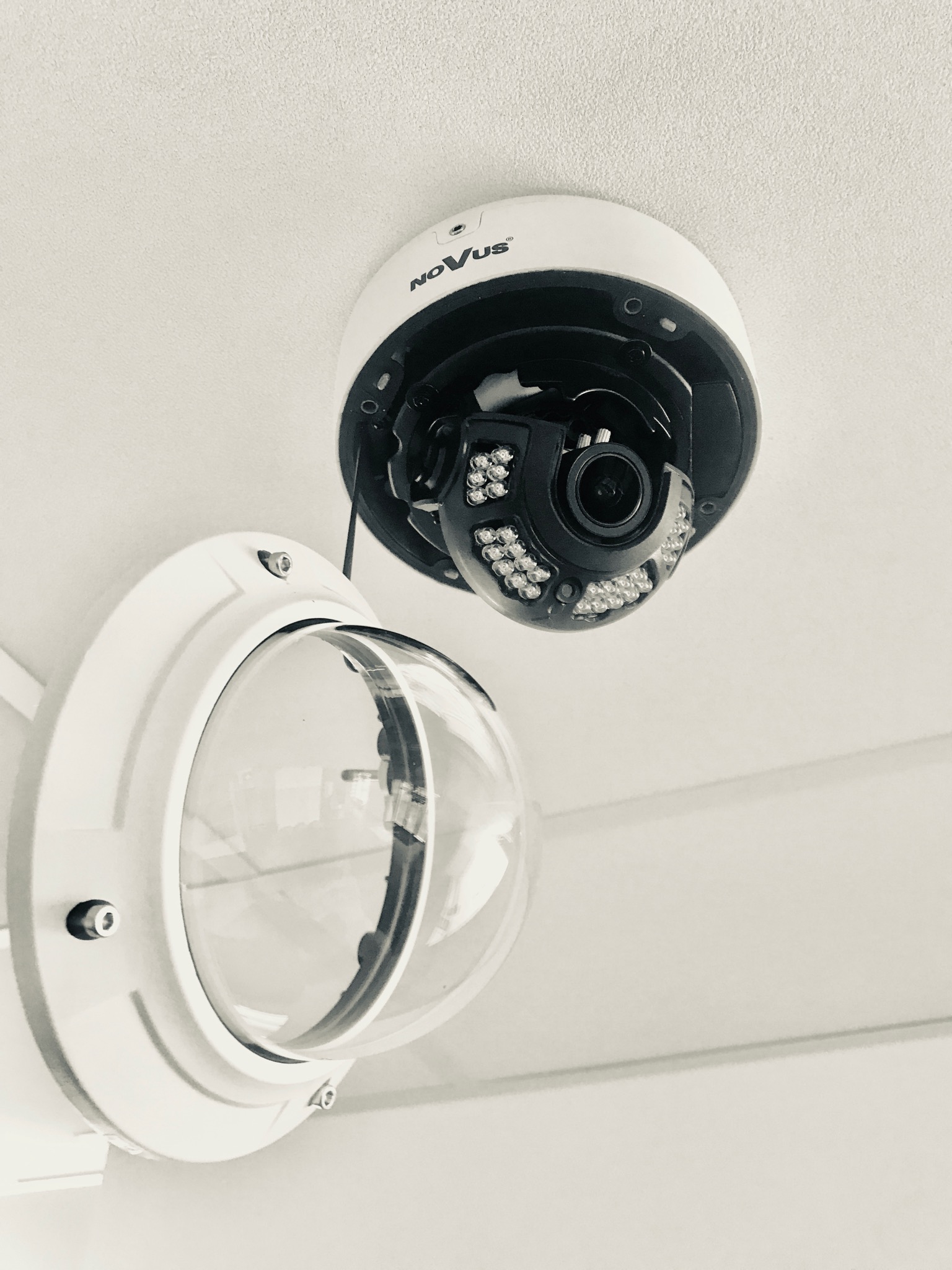 Kamera kopułkowa marki Novus zamontowana na suficie, widoczne diody IR i uchylona obudowa ochronna.