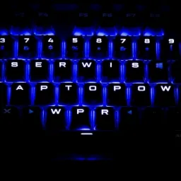 Podświetlana na niebiesko klawiatura z napisem 'SERWIS LAPTOPÓW WPR'.