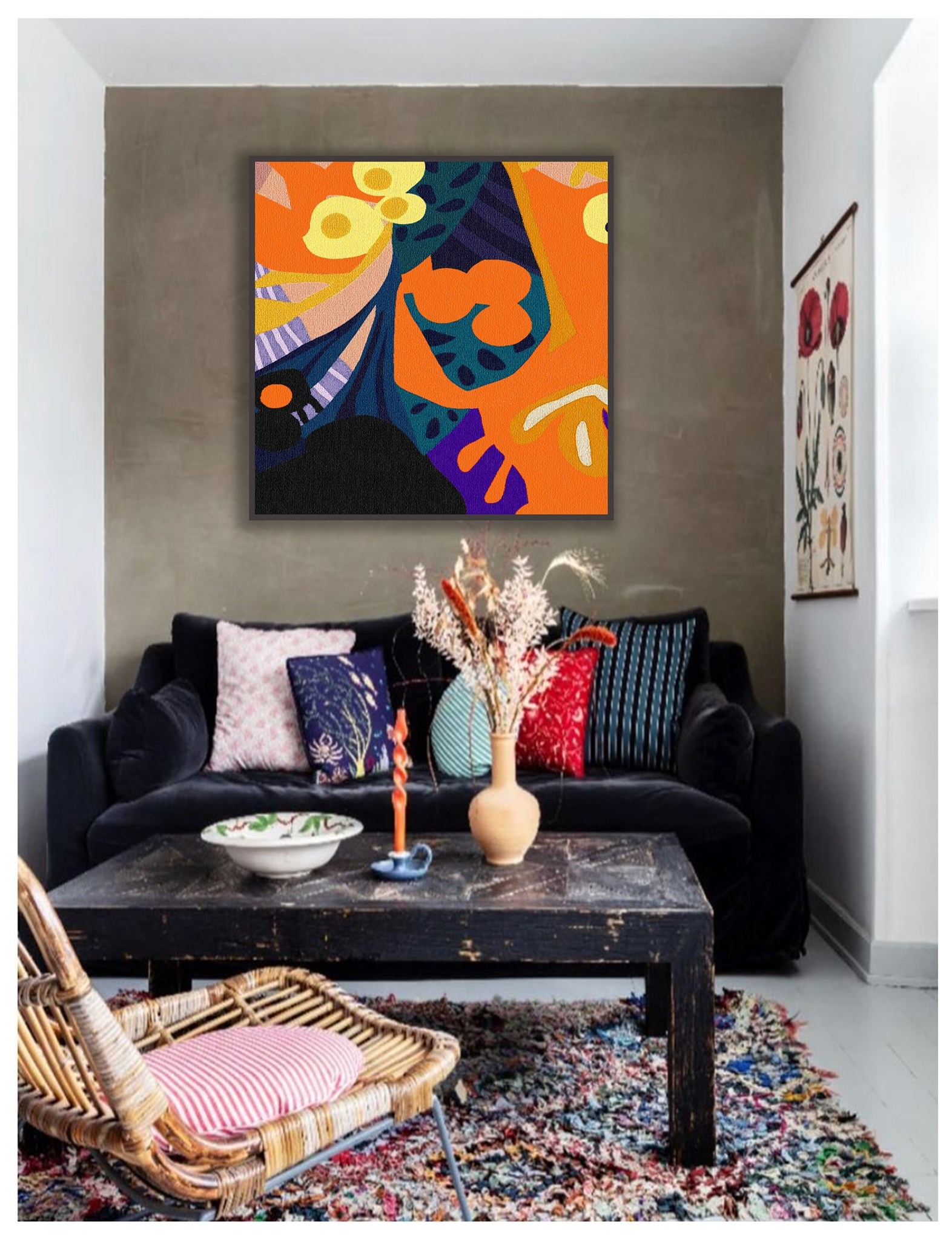 Abstrakcyjny obraz w pomarańczowo-żółto-niebieskich kolorach zawieszony nad czarną sofą z dekoracyjnymi poduszkami w salonie z drewnianym stołem i wiklinowym krzesłem na kolorowym dywanie.