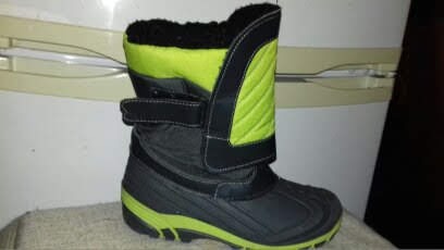 Czarno-zielony but zimowy z zapięciem na rzep, widoczny na tle białej lodówki.