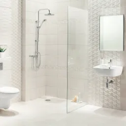 Jasna łazienka z kabiną prysznicową typu walk-in, umywalką wiszącą i toaletą podwieszaną, wykończona płytkami w odcieniach beżu i bieli z geometrycznym wzorem.