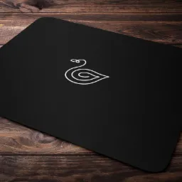 Czarna wizytówka z minimalistycznym logo łabędzia umieszczona na drewnianym tle.