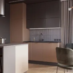 Wnętrze kuchni z wyspą, brązowo-szare szafki z minimalistycznymi uchwytami, okrągły st&oacute;ł z welurowymi krzesłami, kwiaty w wazonie, nowoczesna lampa wisząca nad stołem, drewniana podłoga.