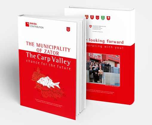 Dwa identyczne, grube tomy książkowe z okładkami w kolorze białym i czerwonym; na pierwszym tomie widnieje mapa z rybą i napis 'The Municipality of Zator', na drugim tomie zdjęcie grupy ludzi...