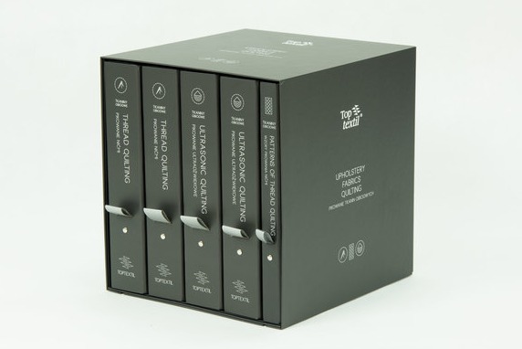 Zestaw wzorników tkanin tapicerskich w czarnym pudełku, zawierający próbki pikowania nicią i ultradźwiękowego. Widoczne napisy na wzornikach: Thread Quilting, Ultrasonic Quilting, Patterns of...