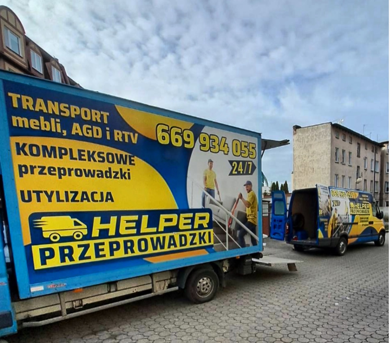 Dwa busy firmy przeprowadzkowej Helper z reklamą transportu mebli, AGD i RTV oraz utylizacji. Jeden bus z otwartymi drzwiami, drugi z numerem telefonu 669 934 055.