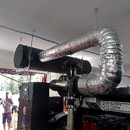 P.H.U. Welding Brothers - Czarny agregat prądotwórczy z systemem odprowadzania spalin w izolacji termicznej, zainstalowany w pomieszczeniu przemysłowym.