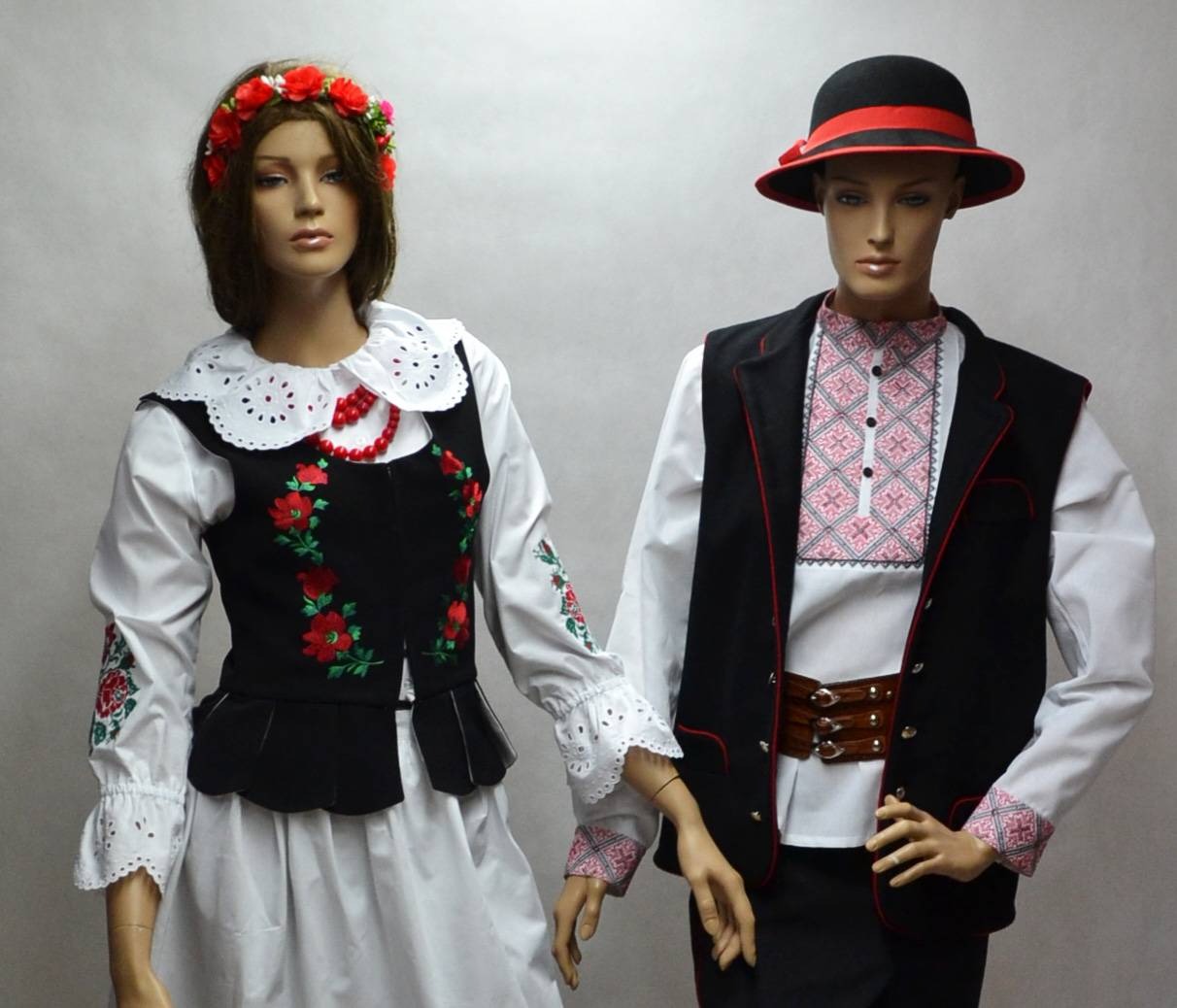 Dwa manekiny prezentujące stroje ludowe: damski z haftowaną kamizelką i wiankiem, męski w koszuli z haftem, kamizelce i kapeluszu.