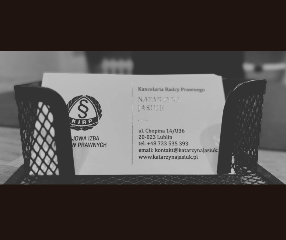 Wizytówka Kancelarii Radcy Prawnego Katarzyna Jasiuk w czarnym metalowym organizerze na biurku, z logo KIRP i danymi kontaktowymi.