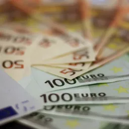 Stos banknotów euro o nominałach 20, 50 i 100 ułożonych wachlarzowo, z delikatnym efektem rozmycia tła.