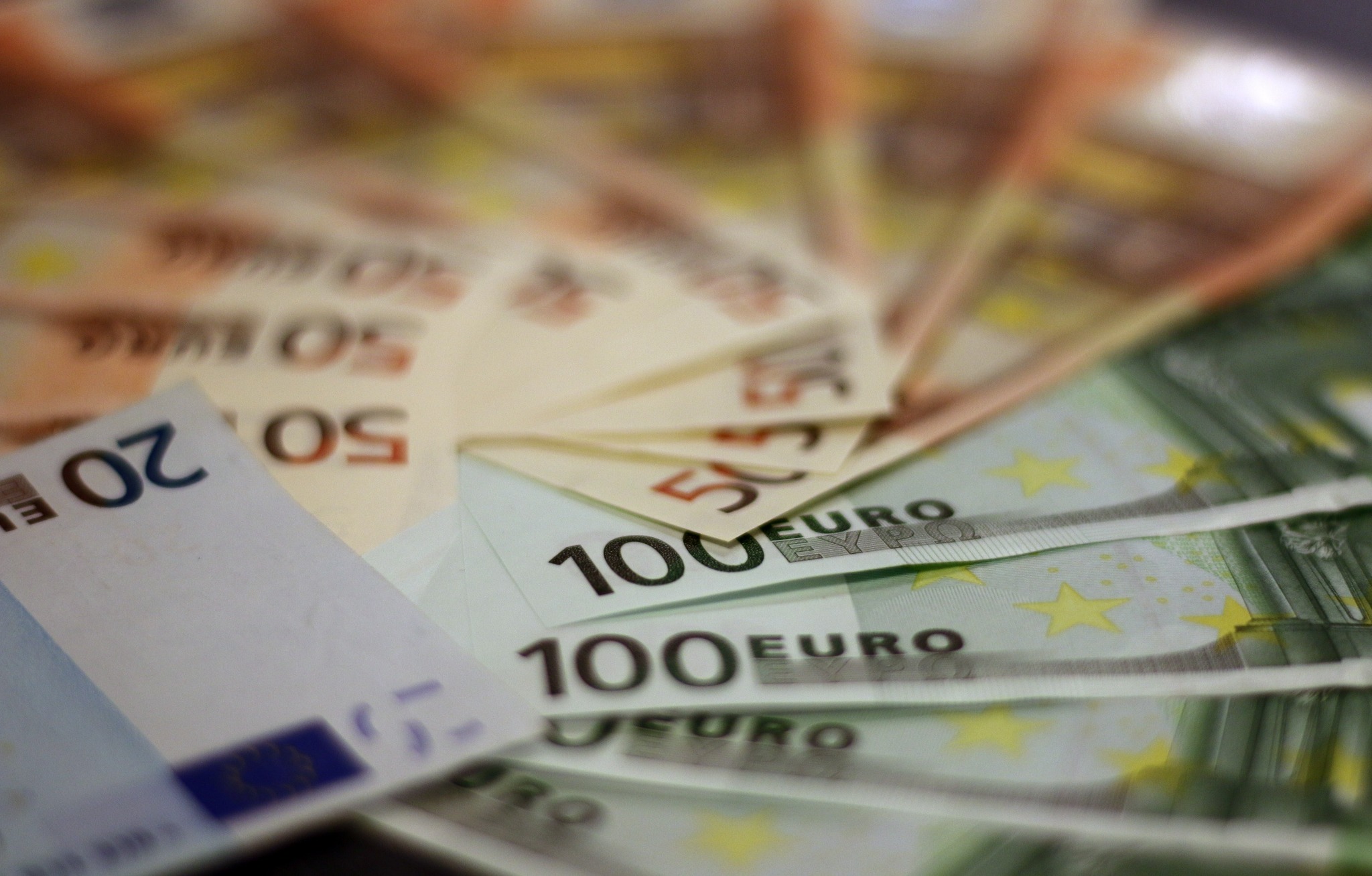 Stos banknotów euro o nominałach 20, 50 i 100 ułożonych wachlarzowo, z delikatnym efektem rozmycia tła.