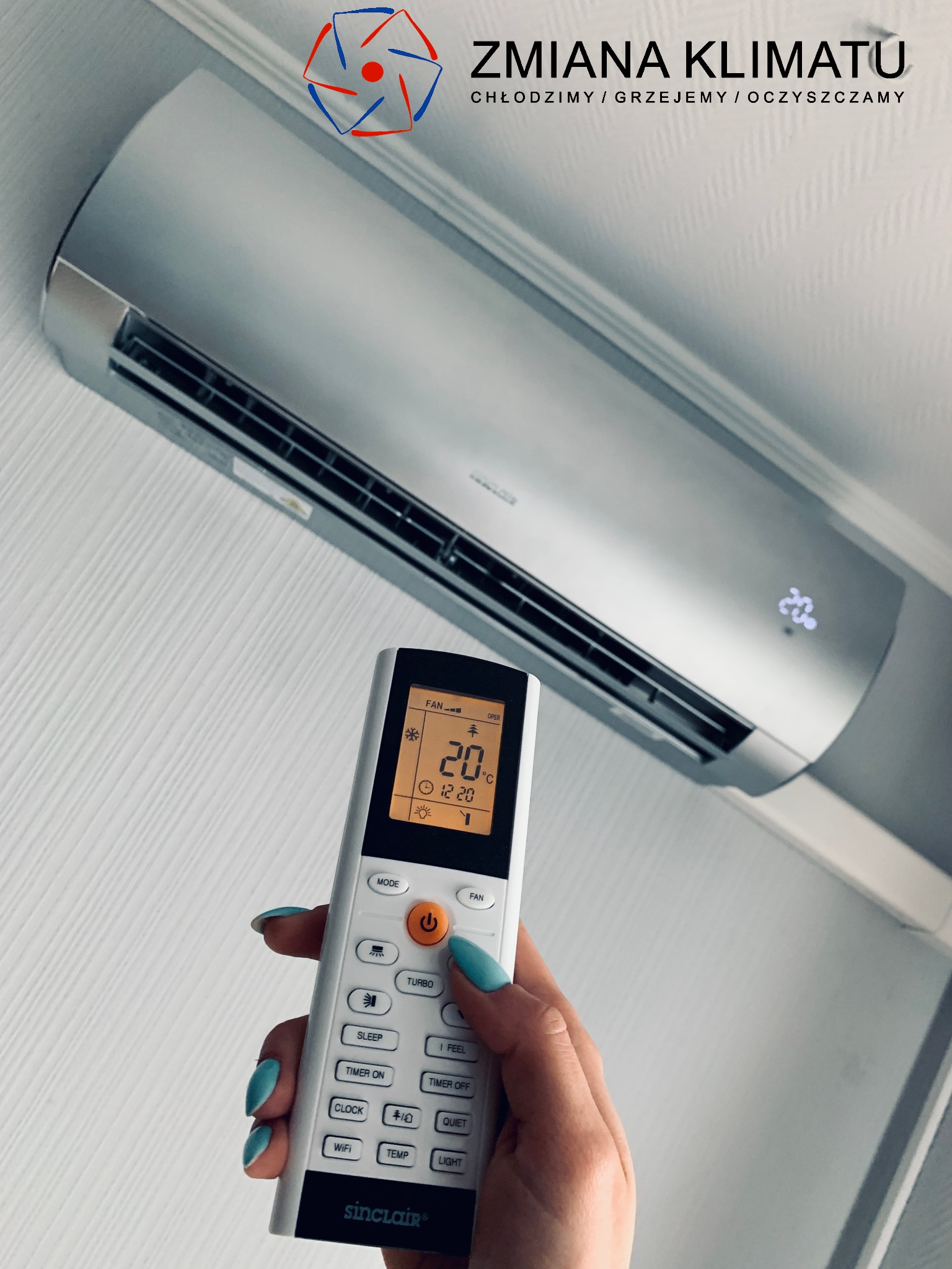 Srebrny klimatyzator Sinclair zamontowany na ścianie, sterowany pilotem trzymanym w dłoni z niebieskim lakierem na paznokciach, ustawiony na 20 stopni Celsjusza, z logo firmy 'Zmiana Klimatu' w tle.