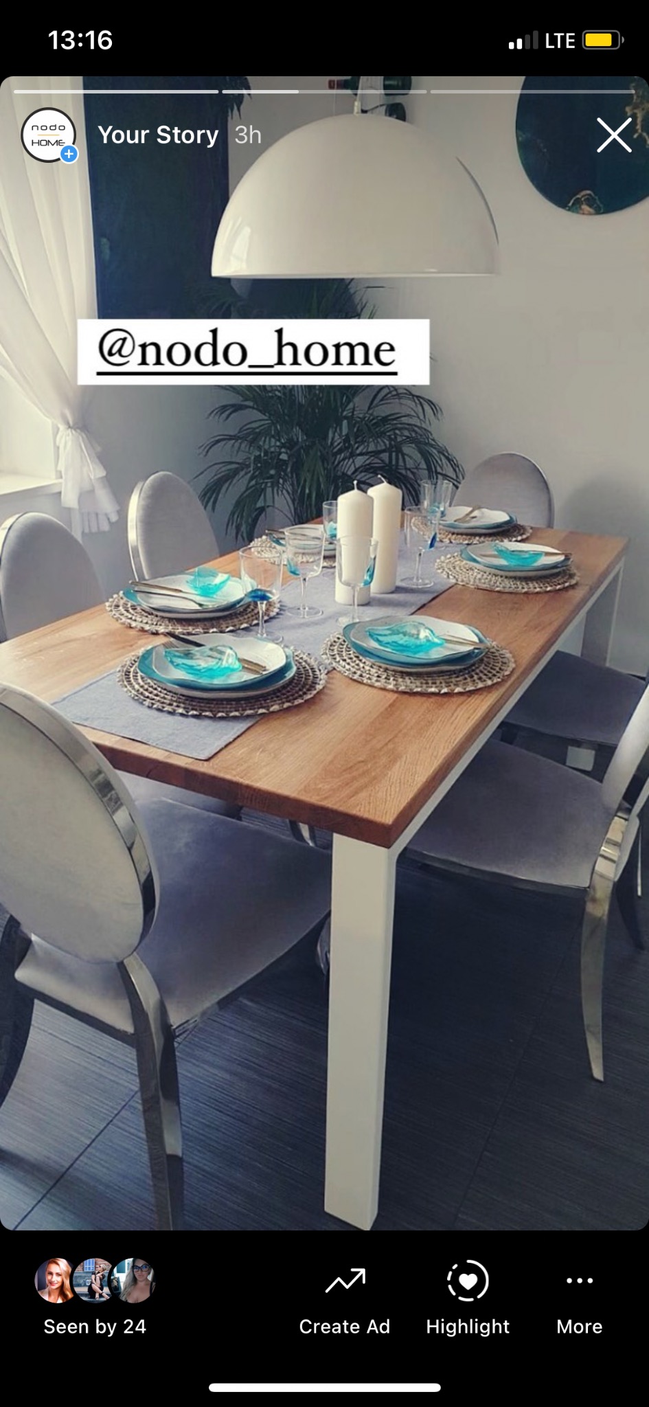 Stół jadalny z blatem z jasnego drewna i białymi nogami, nakryty dla sześciu osób z szarymi bieżnikami, plecionymi podkładkami i turkusowymi akcentami na talerzach, otoczony szarymi krzesłami...