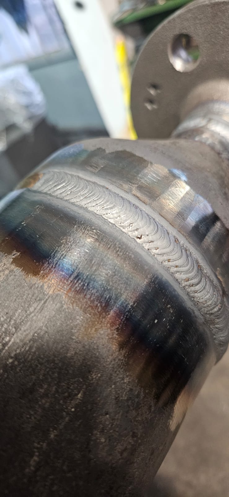 Szczegółowe zbliżenie na spawany element rury z widocznymi śladami spawania i przebarwieniami termicznymi, ukazujące precyzję wykonania.