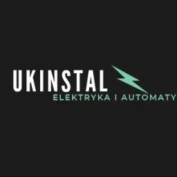 Logo firmy UKINSTAL z symbolem błyskawicy, specjalizującej się w elektryce i automatyce, na ciemnym tle.
