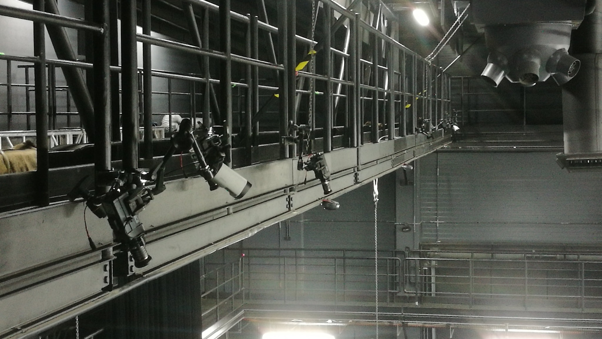 Metalowa konstrukcja z zamontowanymi kamerami przemysłowymi skierowanymi w dół, prawdopodobnie system monitoringu w hali przemysłowej