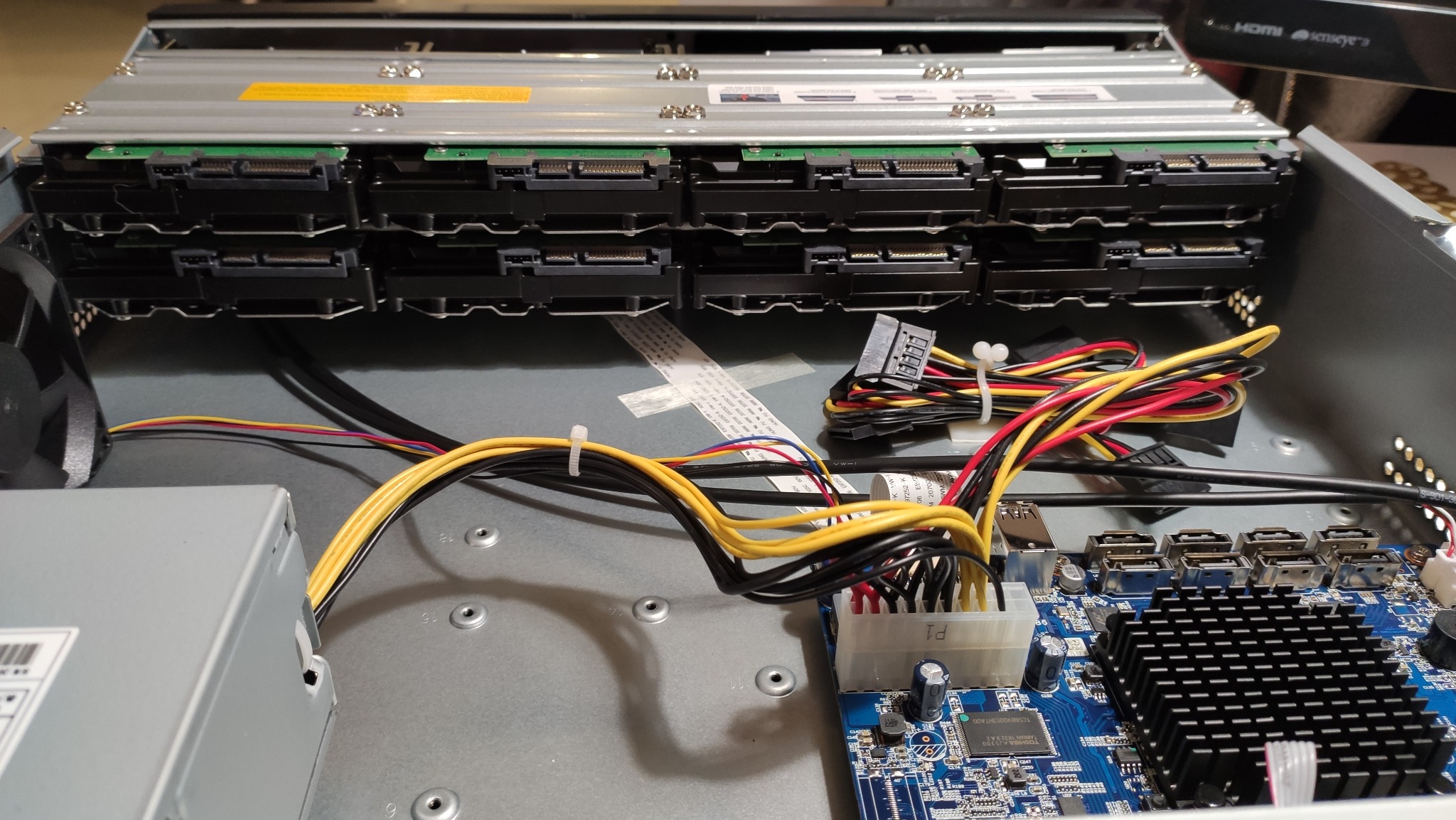 Wnętrze serwera z zamontowanymi dyskami twardymi, widoczne okablowanie i płyta główna.