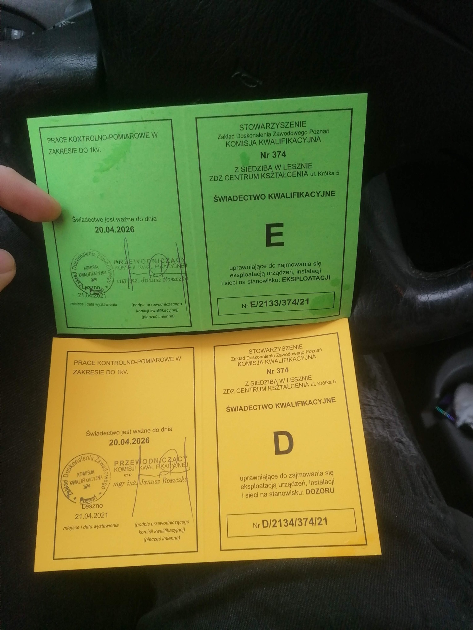 Dwa świadectwa kwalifikacyjne, jedno zielone z kategorią E, drugie żółte z kategorią D, uprawniające do prac kontrolno-pomiarowych w zakresie do 1kV, wydane przez Stowarzyszenie Zakład Doskonalenia...