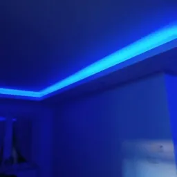 Sufit podwieszany z niebieskim oświetleniem LED, widok z dołu na róg pokoju.