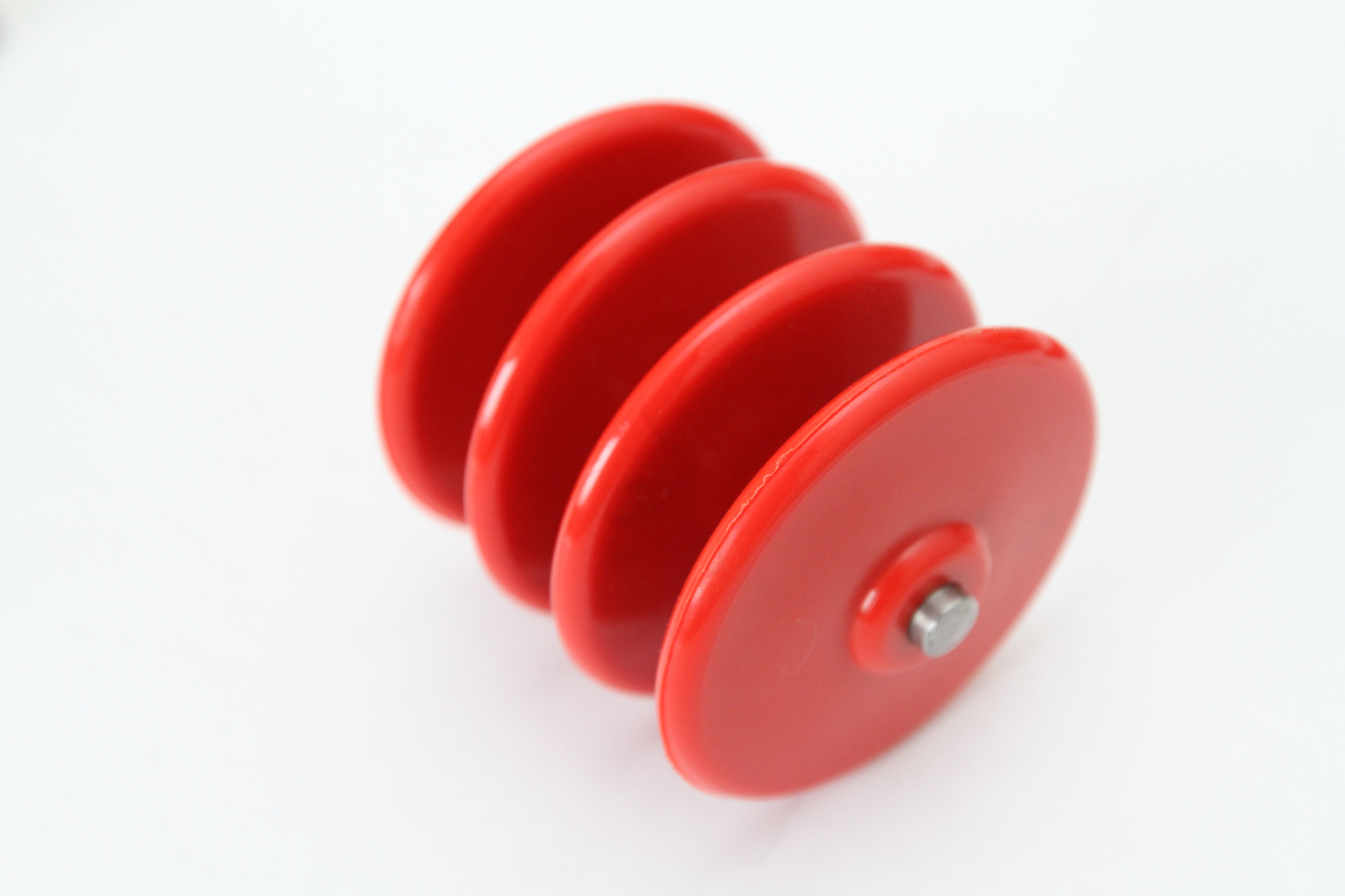 Czerwone liczydło z czterema koralikami na białym tle, widoczne mocowanie na osi.