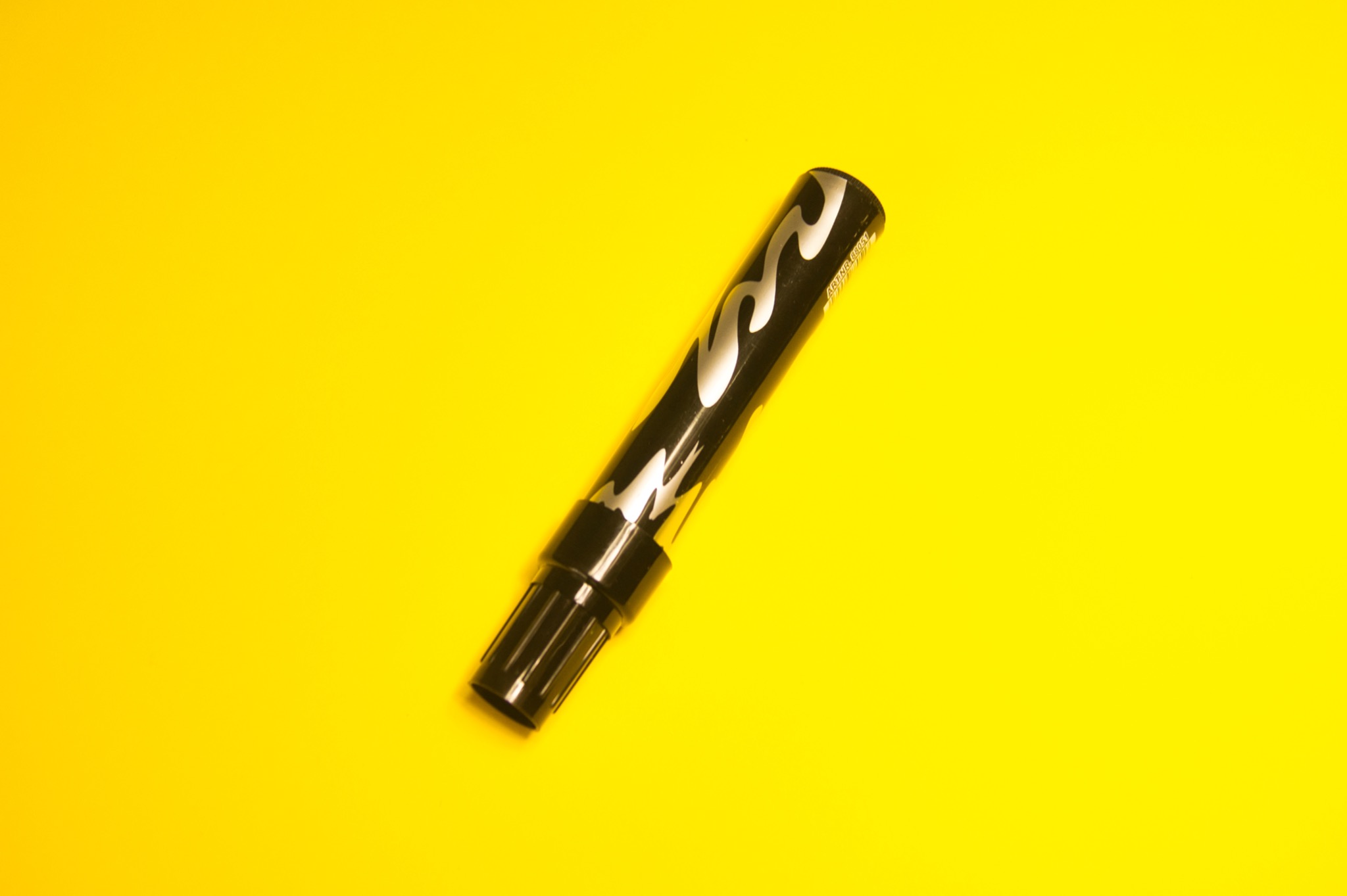 Czarny marker graficzny z srebrnymi zdobieniami na jaskrawożółtym tle, wykonany przez firmę z Bielska-Białej.