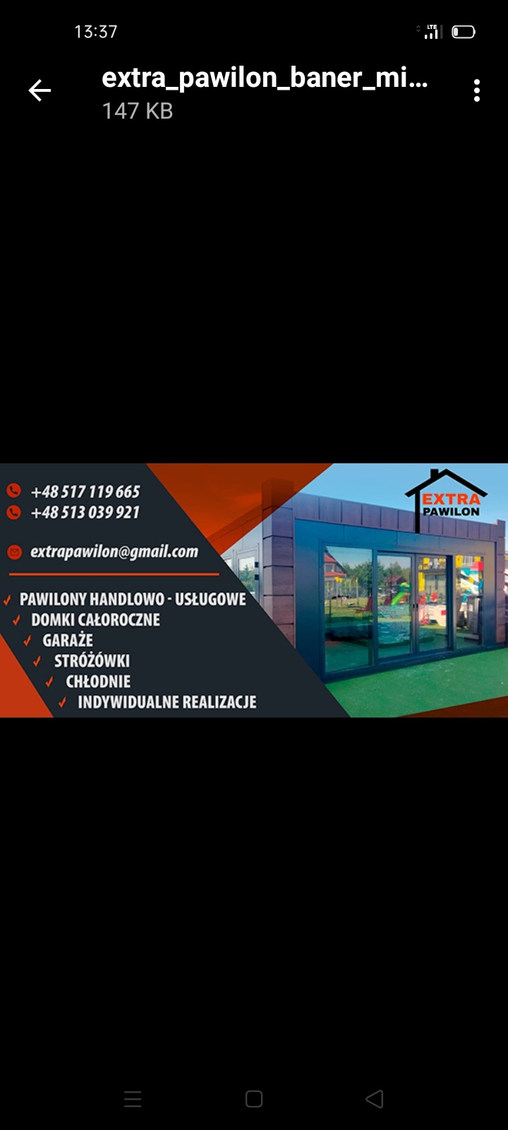 Baner reklamowy firmy Extra Pawilon prezentujący pawilon handlowo-usługowy z płyt warstwowych z ciemną elewacją, widoczne dane kontaktowe i logo firmy.