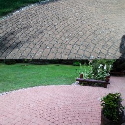 WAHOsoftwash Mycie Elewacji Bez Ciśnienia - Czyszczenie Kostki Brukowej - Pranie Tapicerki - Mycie Kostki Brukowej - AntyMech - Porównanie czyszczenia kostki brukowej: górna część zdjęcia pokazuje zabrudzoną kostkę, dolna część prezentuje efekt po umyciu, z widocznym logo firmy.