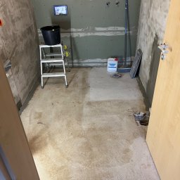 „JUPINEX “ Adam Jueppner - Przygotowanie do prac wykończeniowych w łazience: ściany z płyt karton-gips, grunt, drabina, wiadro, narzędzia. Widoczne instalacje i otwory pod armaturę.