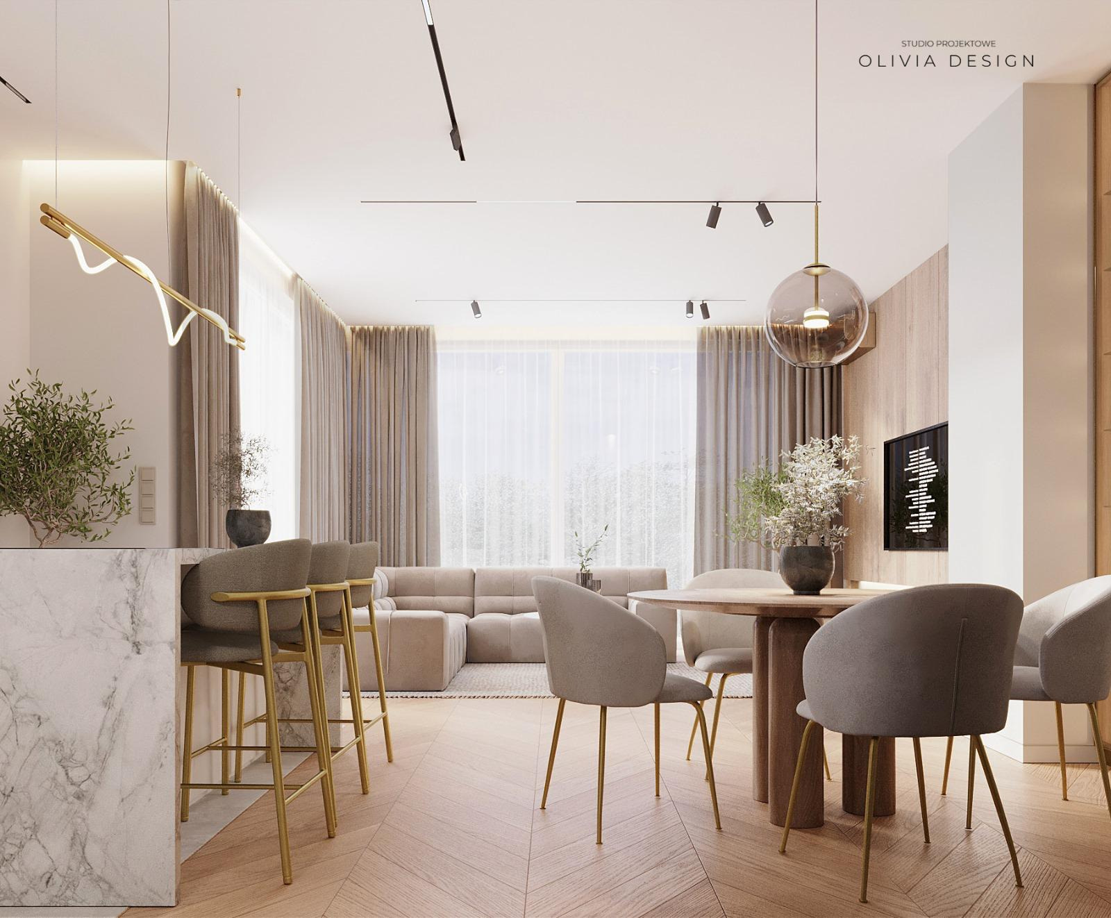 Jasne, przestronne wnętrze salonu z aneksem jadalnym, z marmurowym blatem baru, okrągłym stołem i beżową sofą narożną, oświetlone nowoczesnymi lampami sufitowymi i podłogą z parkietu ułożonego...