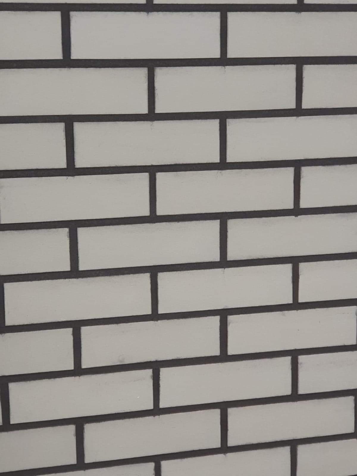 Ściana z białych, prostokątnych cegieł z ciemnoszarą fugą, ułożonych w regularnym wzorze.