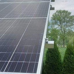 Metis Polska - Panel słoneczny na aluminiowej konstrukcji wsporczej, widok z dołu na tle zieleni i pochmurnego nieba.